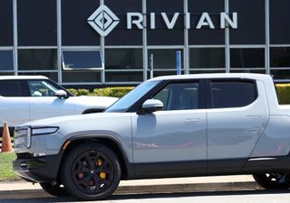 A white Rivian electric truck outside of dealership