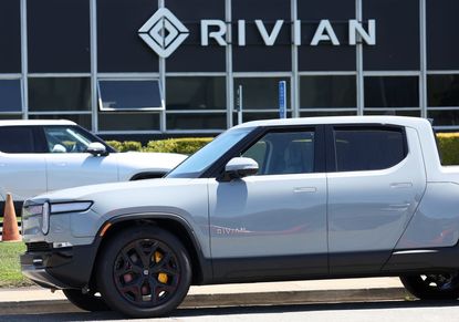 A white Rivian electric truck outside of dealership