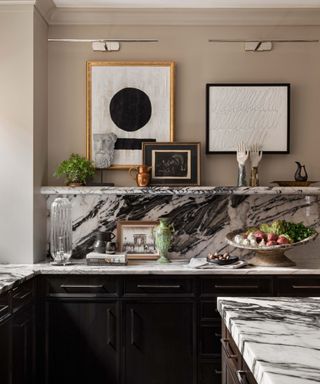 kitchen with neutral wall, black cabinets and marble counters and backsplash