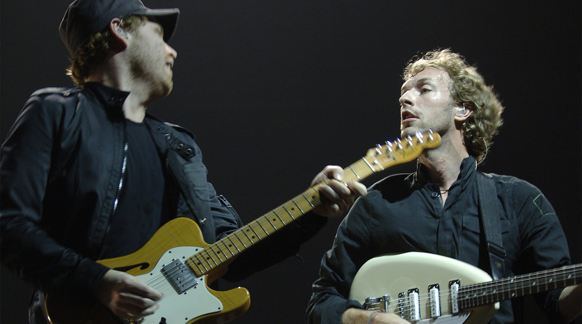 Jonny Buckland and Chris Martin and Coldplay perform At Continental Airlines Arena on March 25, 2006 in East Rutherford, New Jersey.