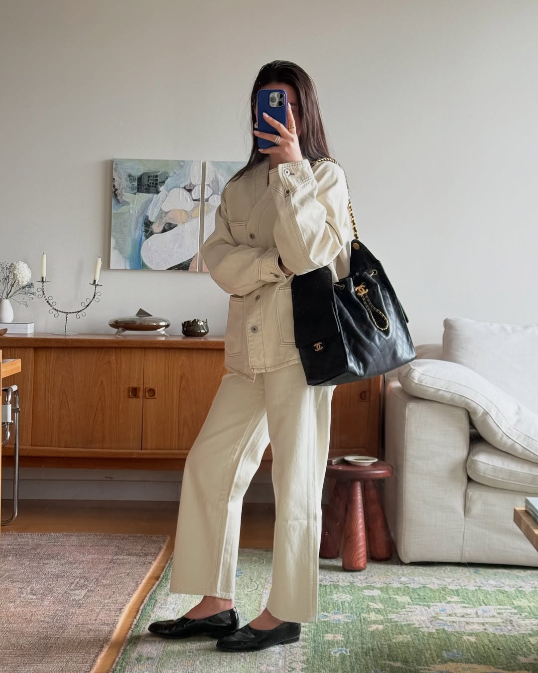 Sasha in white jeans and jean jacket and black loafers