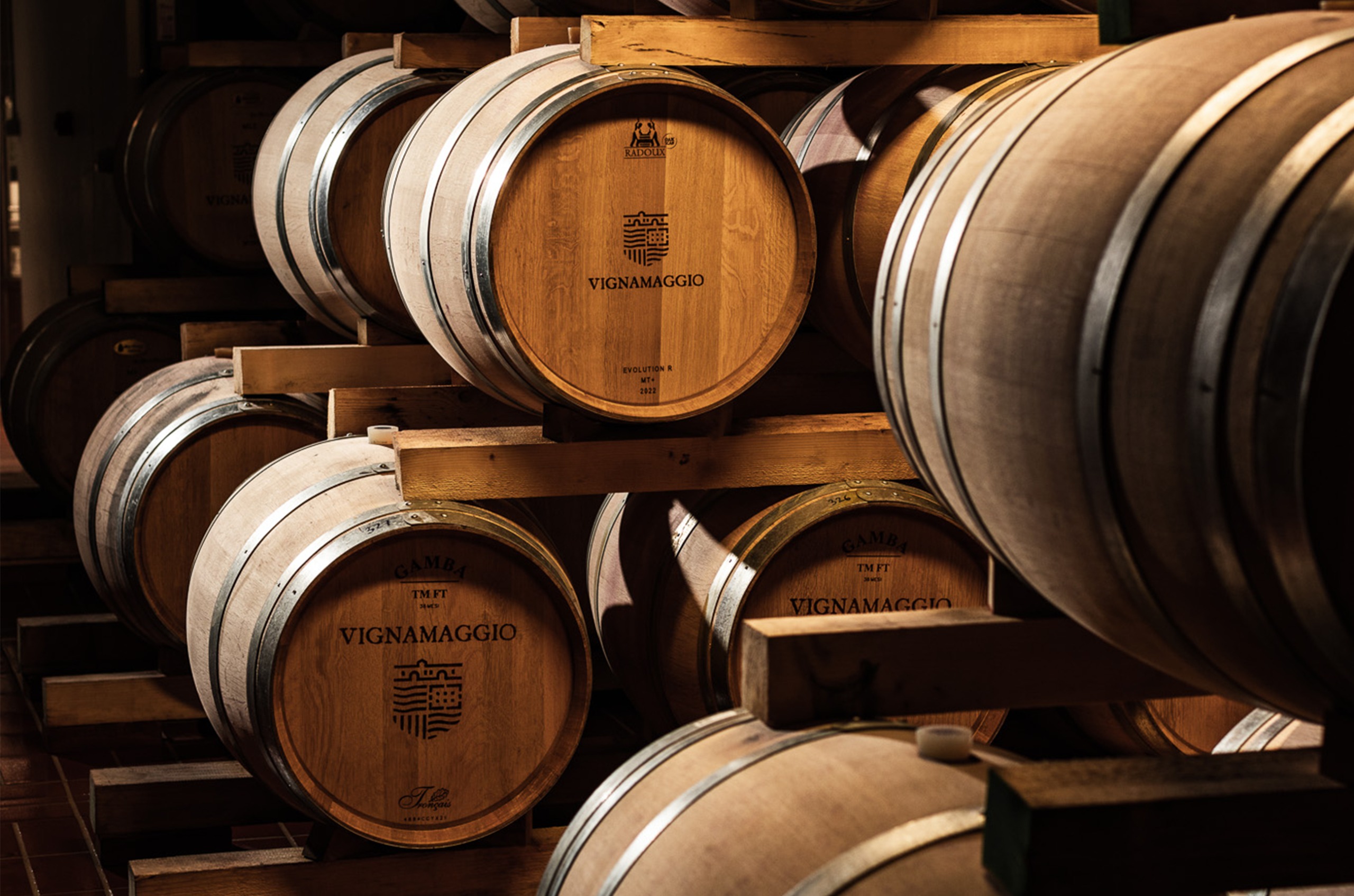 Oak barrels stacked on top of each other, with 'Vignamaggio' on them
