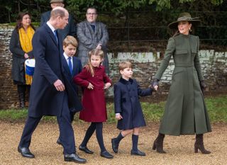 Prince William wears a navy suit and Kate Middleton wears a long green coat and brown heeled boots and a green hat while they take their three kids, Prince George, Princess Charlotte, and Prince Louis, to church