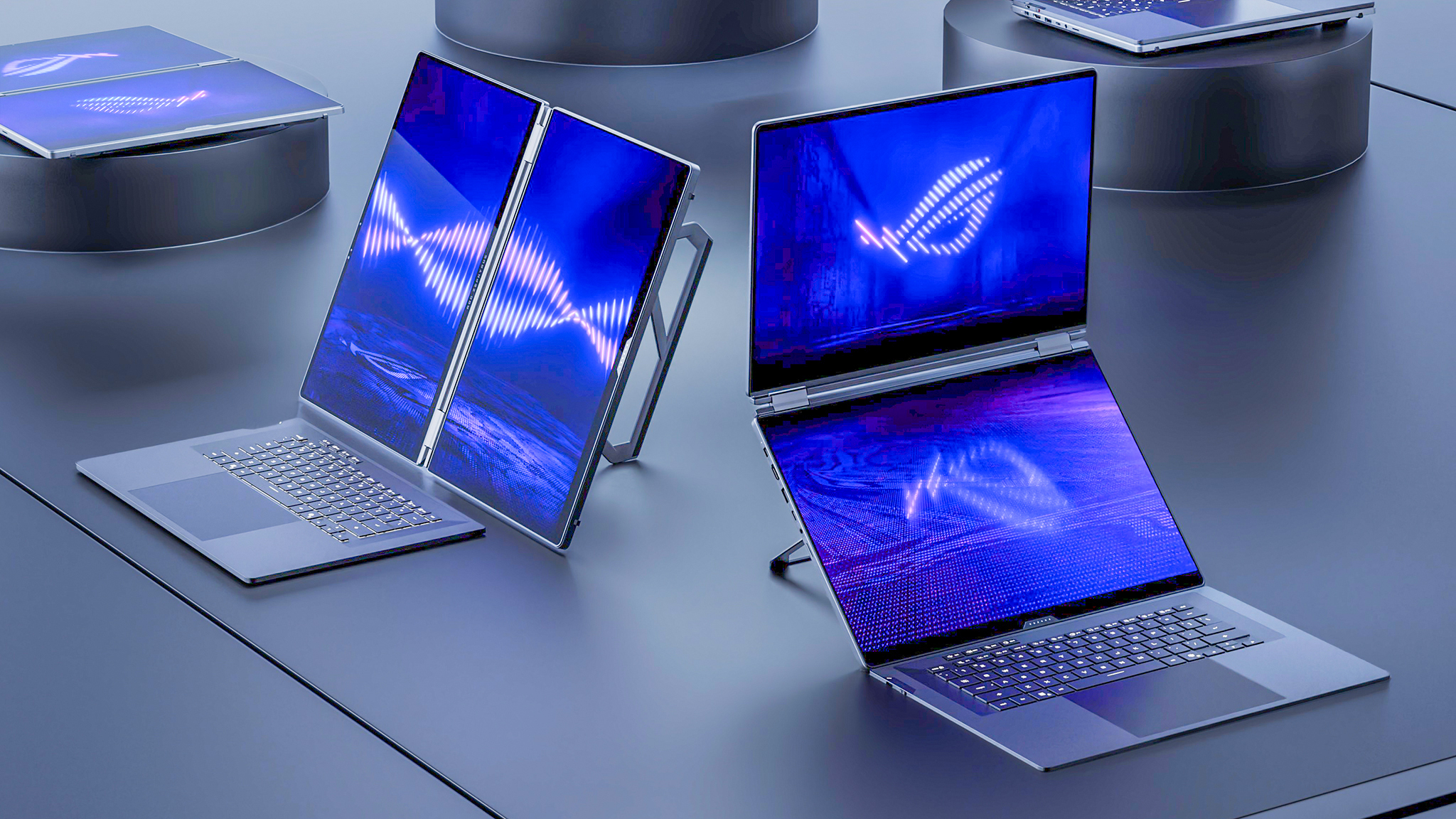 Two ASUS Zenbook Duo laptops, one in portrait mode the other in landscape mode. 