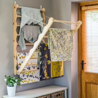 Wooden wall mounted ladder with clothes and towels
