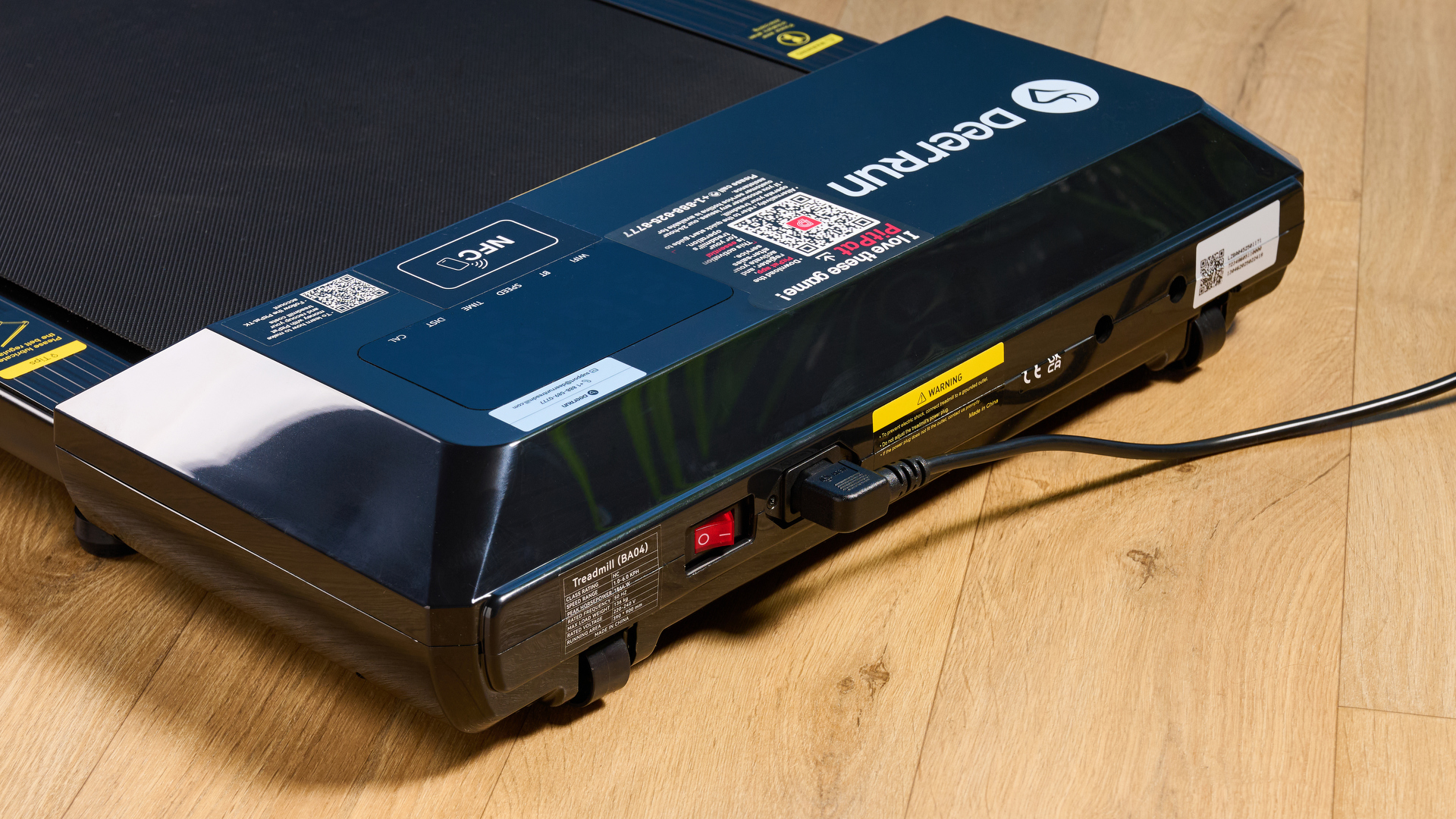 the deerrun q1 mini under desk treadmill walking treadmill in a home office with a blue wall and wooden floor