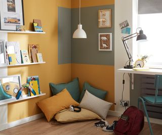corner of bedroom with green panel on yellow wall and cushions on floor
