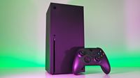 Vertical black Xbox Series X console and controller sitting together, dramatized by vibrant green and purple background lights.
