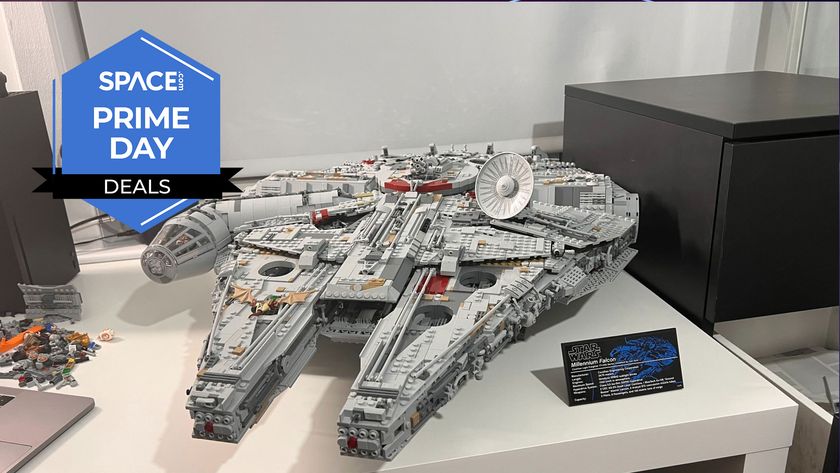 A Lego space ship in the shape of a disk at the rear and two pointed parts at the front is sitting on a white desk with the space.com logo in the top left corner.