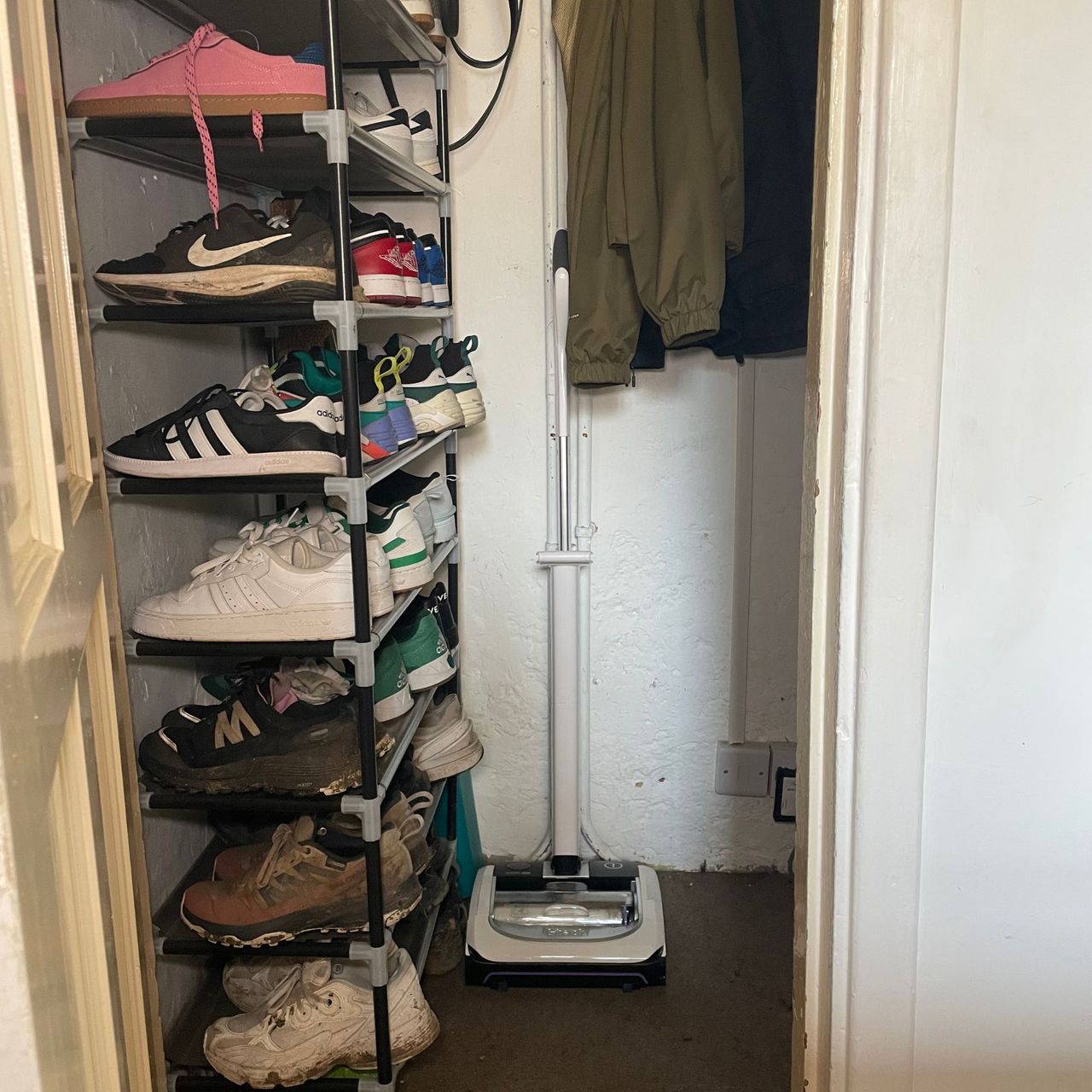 Gtech AirRam Platinum stored in an under-the-stairs cupboard, next to a shoe rack