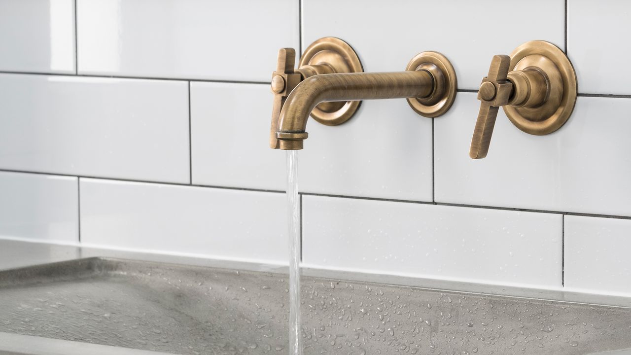 White metro tiles with gold tap and concrete sink