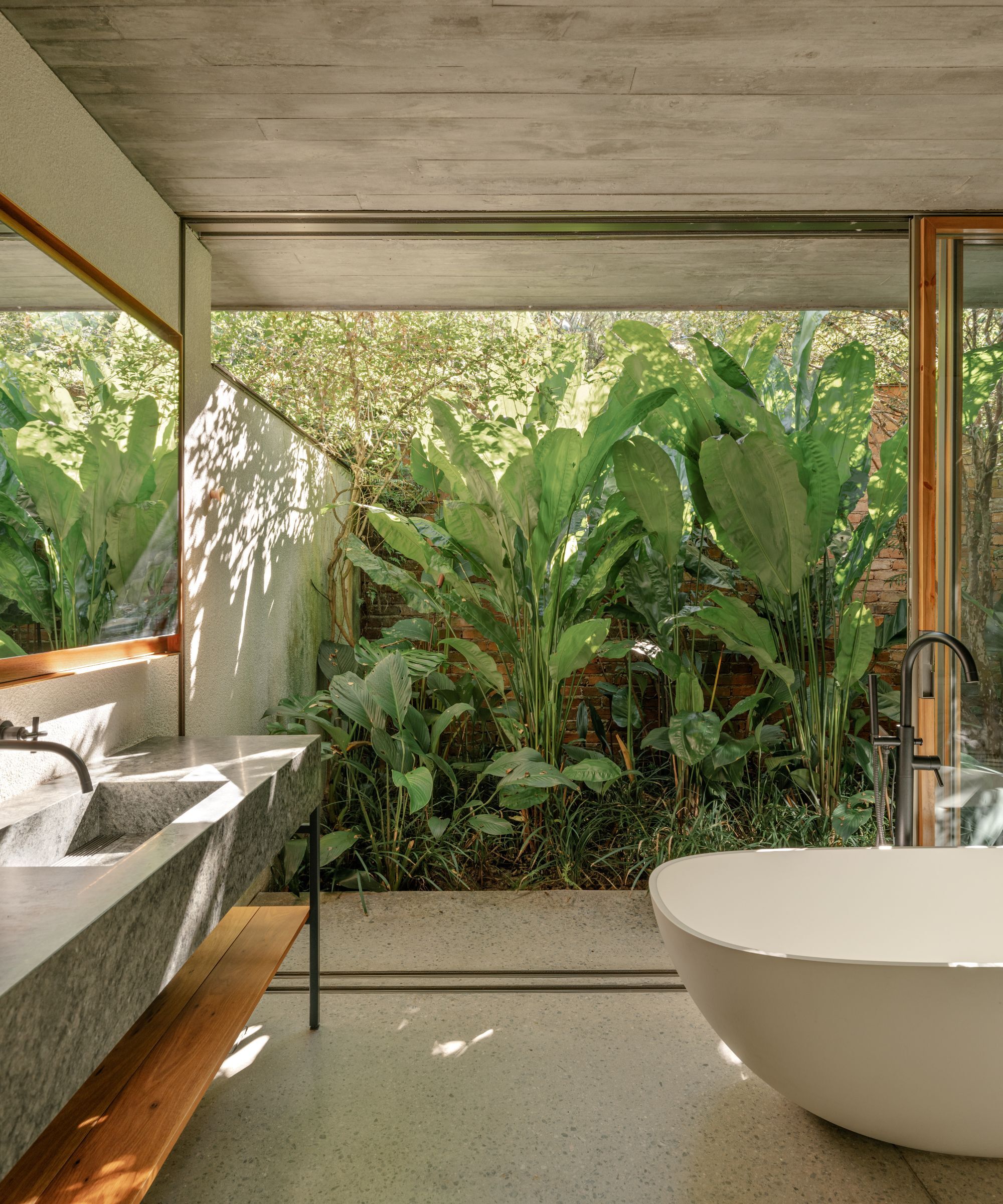 Open plan modern bathroom with a tropical courtyard garden