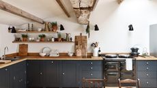 dark painted shaker kitchen with wooden shelves