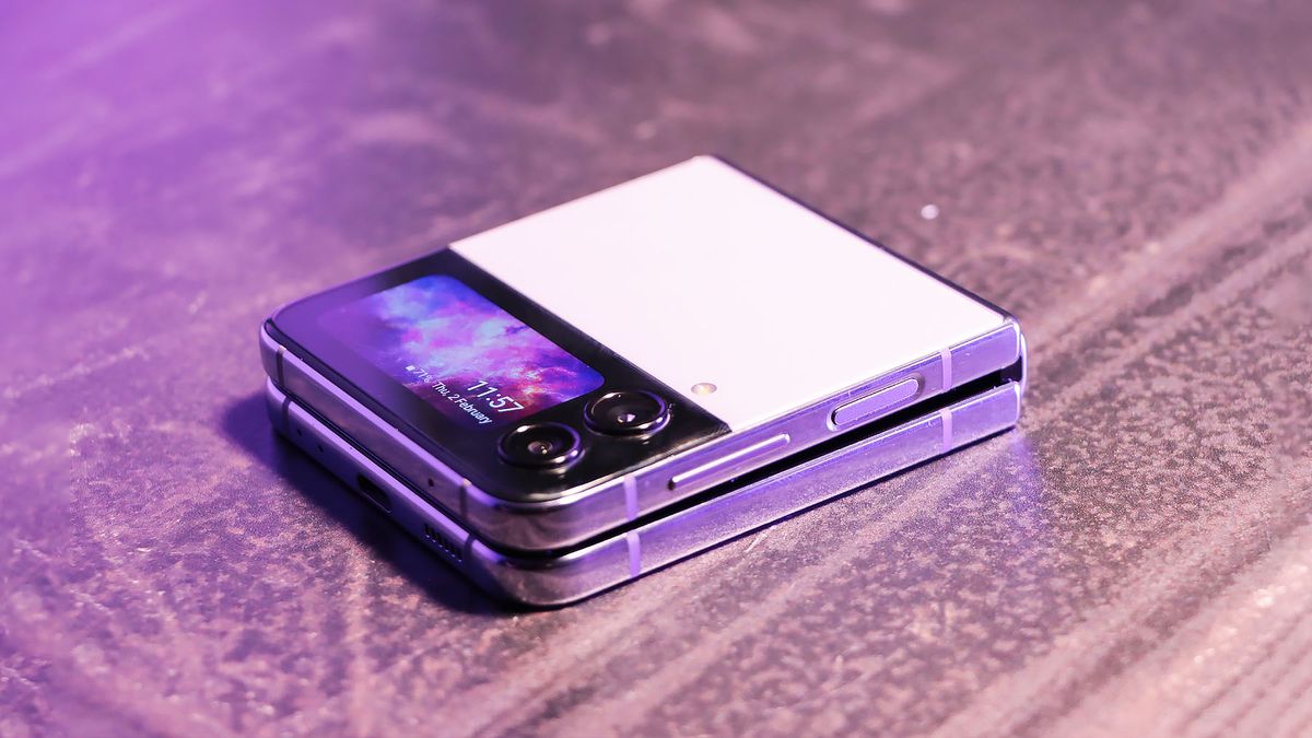 A shot of the Samsung Galaxy Z Flip4 phone folded over on a dark table