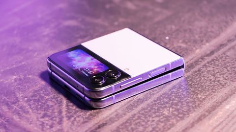 A shot of the Samsung Galaxy Z Flip4 phone folded over on a dark table