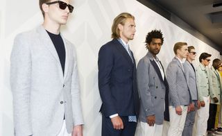 Eight guys wearing the Hardy Amies S/S 2015 collection. Each guy is wearing a different outfit with colours ranging from white, gray, navy, minty green to shocking sunny yellow.
