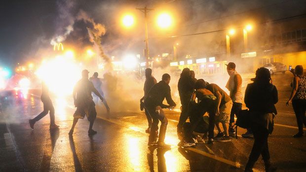 Armed police fire tear gas at demonstrators following the shooting of Michael Brown 