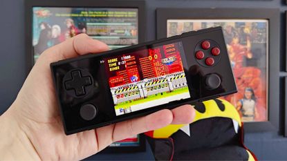 Hand holding Ayaneo Pocket Micro handheld with Sonic the Hedgehog 2 Chemical Plant Zone gameplay on screen.