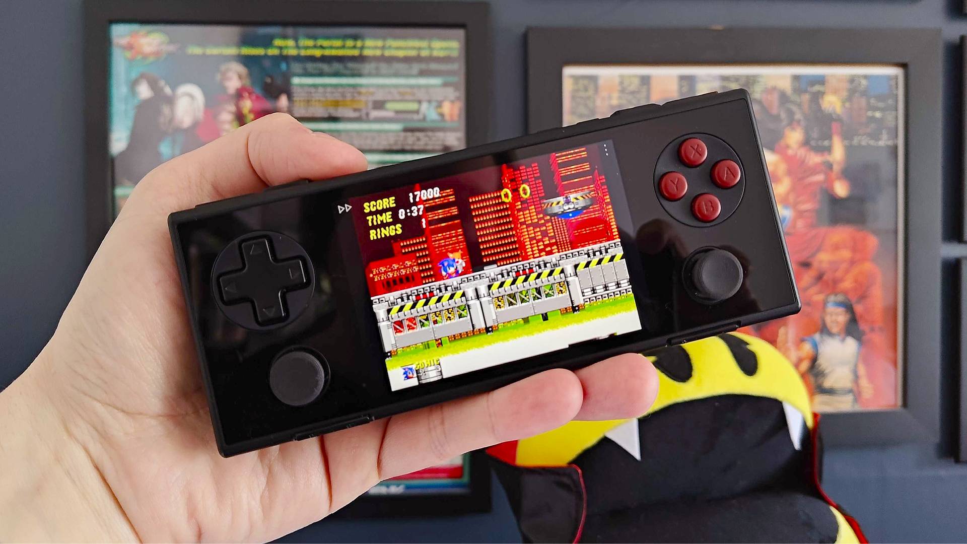 Hand holding Ayaneo Pocket Micro handheld with Sonic the Hedgehog 2 Chemical Plant Zone gameplay on screen.