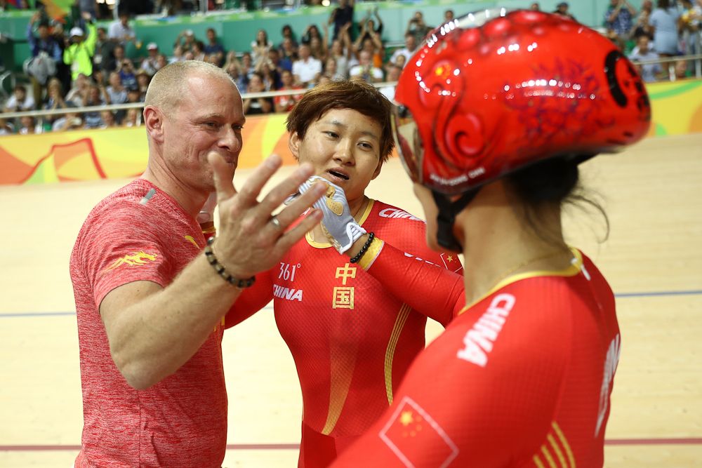 Jinjie Gong (R) and Tianshi Zhong (C) of Team China celebrates winning the gold medal with their coach after beating Team Russia in the Women's Team Sprint final for gold