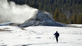 一个滑雪者穿过间歇泉盆地在黄石国家公园