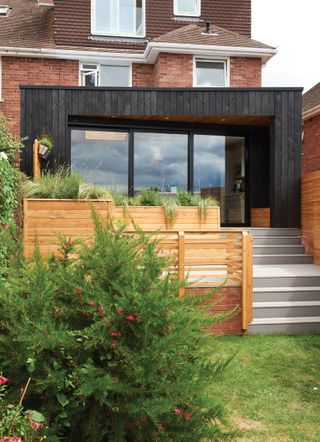 modern timber clad extension on sloping site