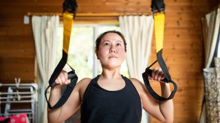 Woman using suspension trainer at home