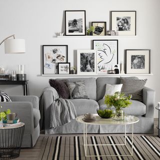 room with wall frame grey sofa cushions and white floor lamp