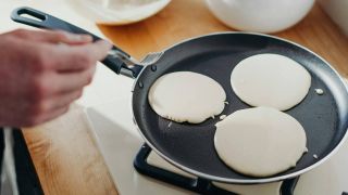 Someone making pancakes in a non-stick pan