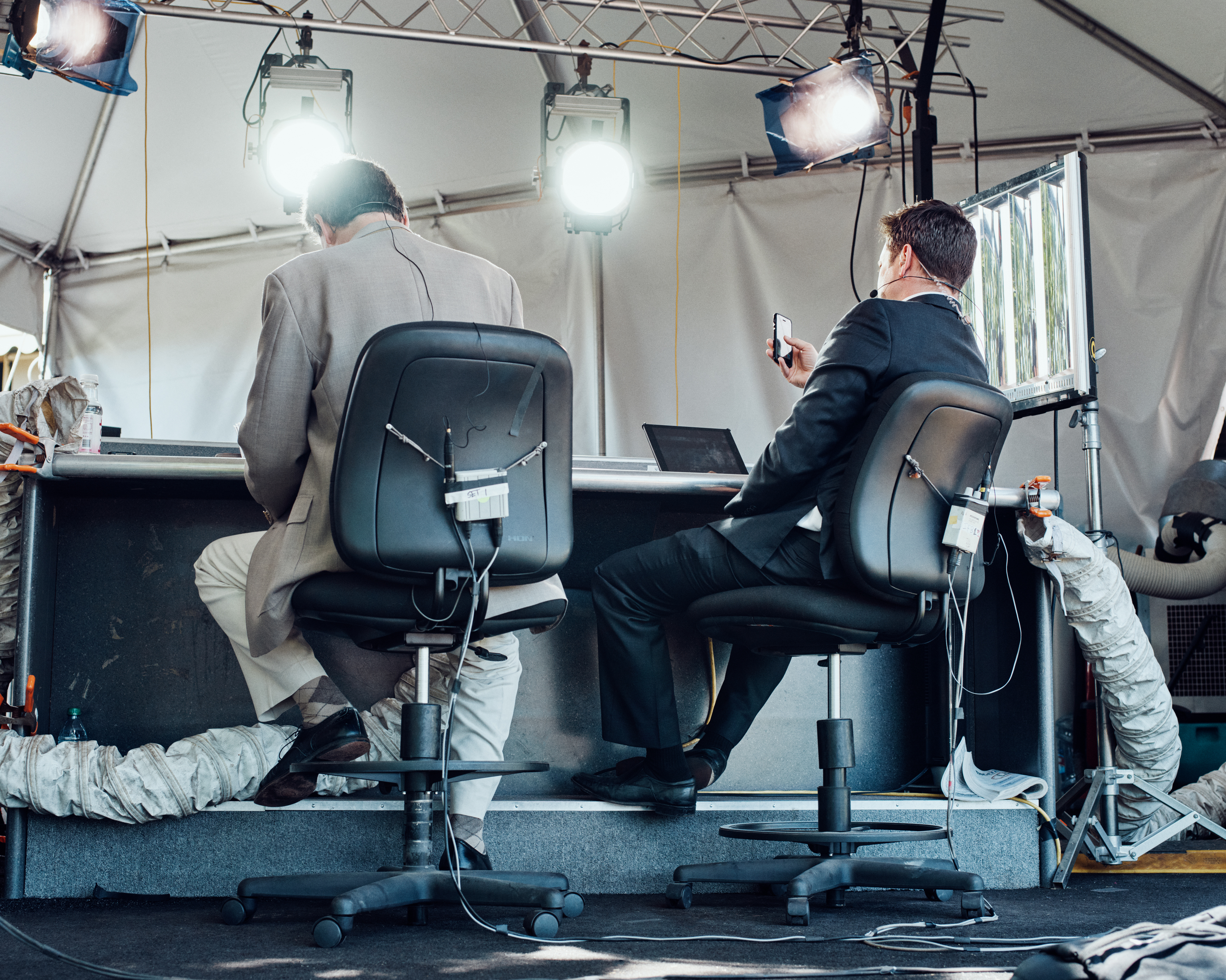 photography of two men in a tented workspace, in chairs at a counter