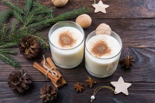 Two glasses of eggnog sprinkled with cinnamon