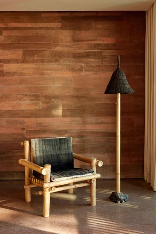 An image of a chair and tall standing lamp in a guest bedroom