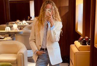 Olympia Gayot in a white pinstripe blazer, blue button down, and jeans.