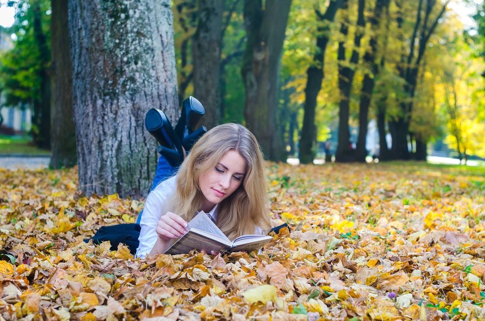 Girl with a book in an autumn park.