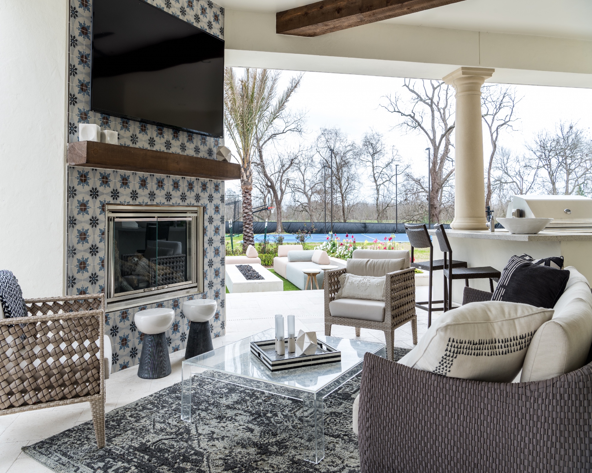 Corner fireplace on blue wallpapered hearth with glass top dining table in the back