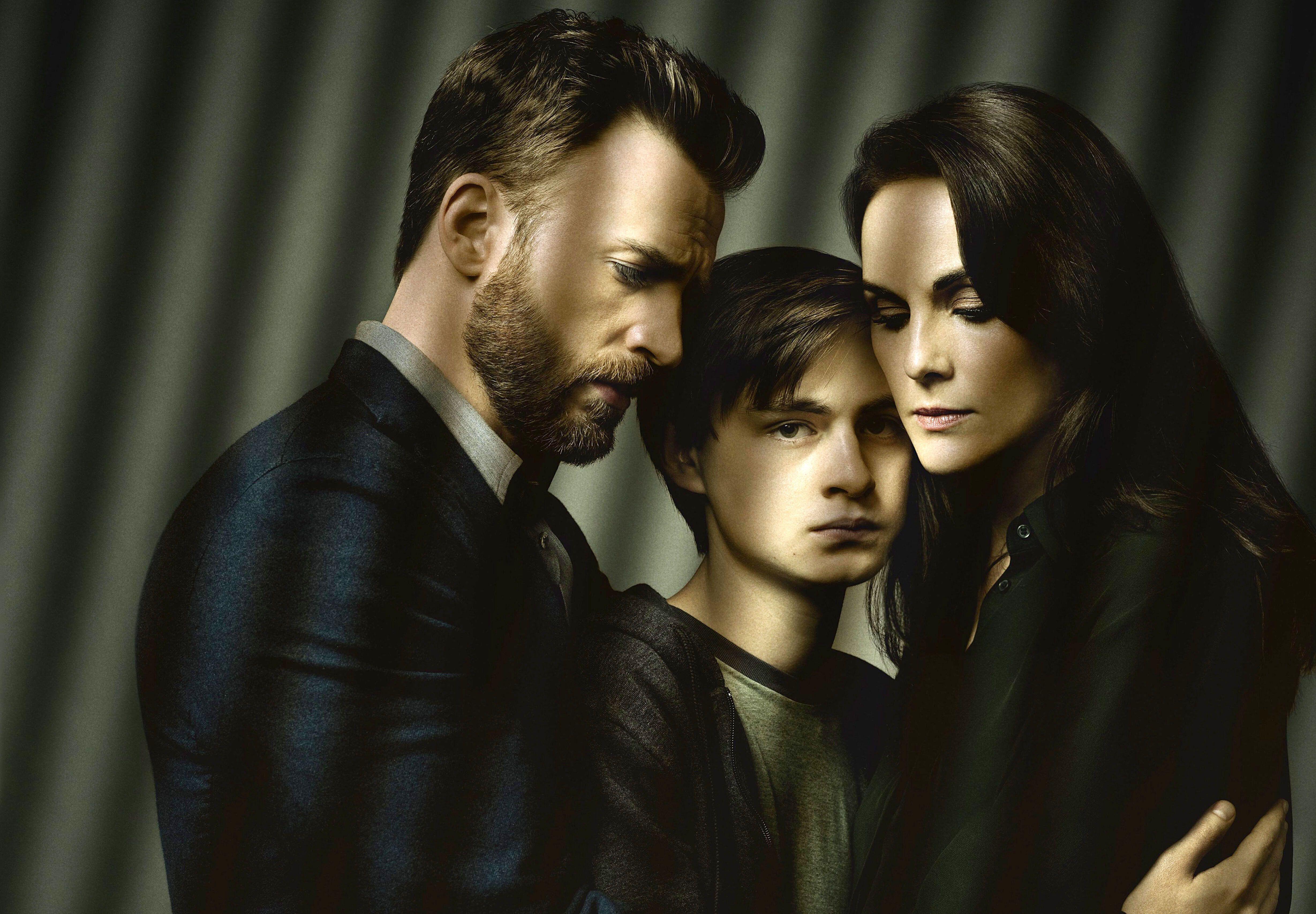 two parents console their teen son in a dimly lit room in a still from the tv show defending jacob