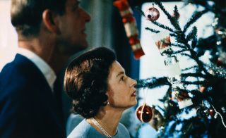 (Original Caption) Christmas at Windsor Castle is shown here with Queen Elizabeth II and Prince Philip shown putting finishing touches to Christmas tree, in a photo made recently during the filming of the joint ITV-BBC film documentary, The Royal Family.