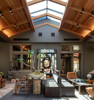 Converted barn style modern living room and dining room with use of greys, natural stone flooring and browns