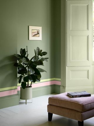 sage green wall close-up with pastel pink stripe above skirting