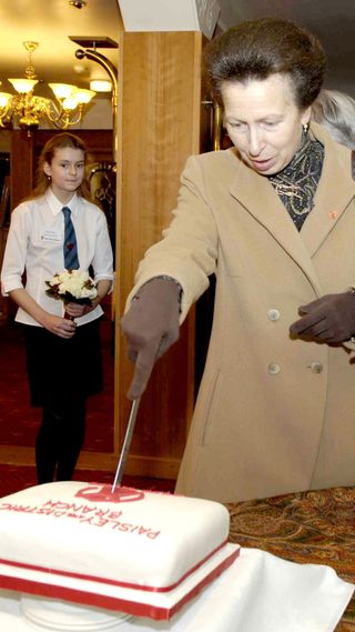 Princess Anne slicing a cake