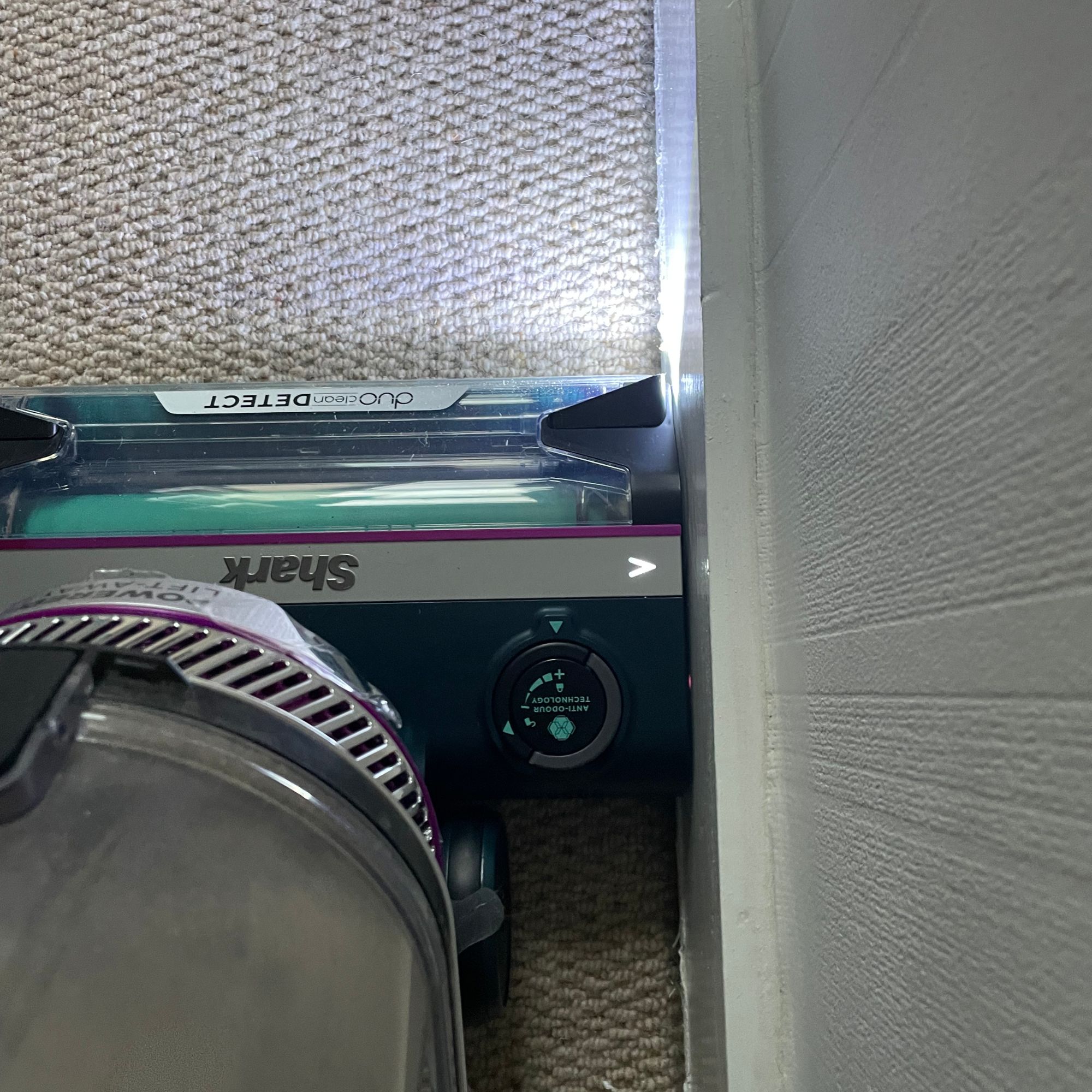 Shark PowerDetect Powered Lift-Away Upright Pet Vacuum Cleaner AZ3900UKT cleaning right up to the edge of a skirting board, with lights on the front of the floorhead