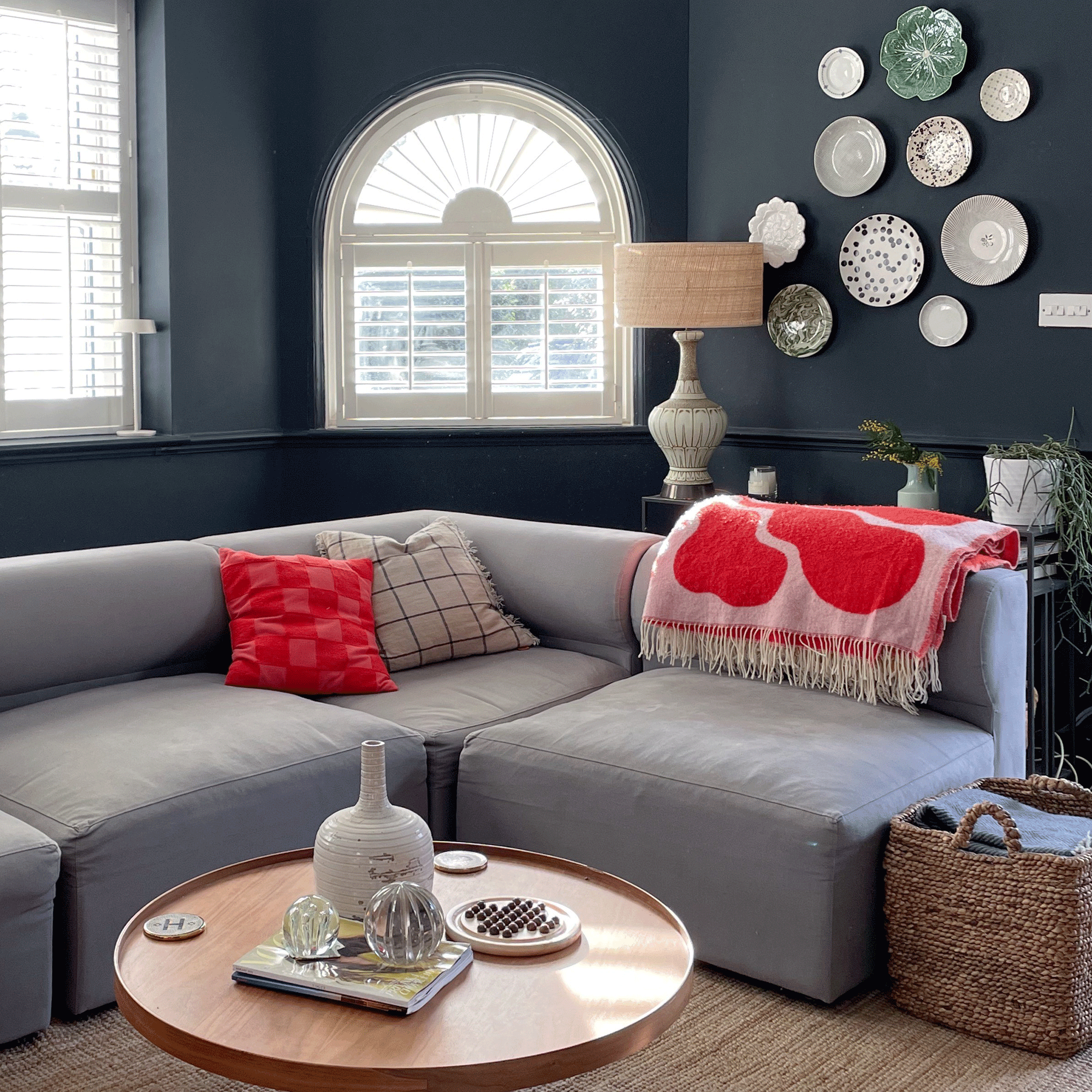 black living room with grey sofa and pink blanket