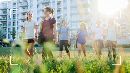 Group of women wearing activewear and carrying bags walking over grass close to high rise buildings, laughing and smiling, after learning does walking build muscle