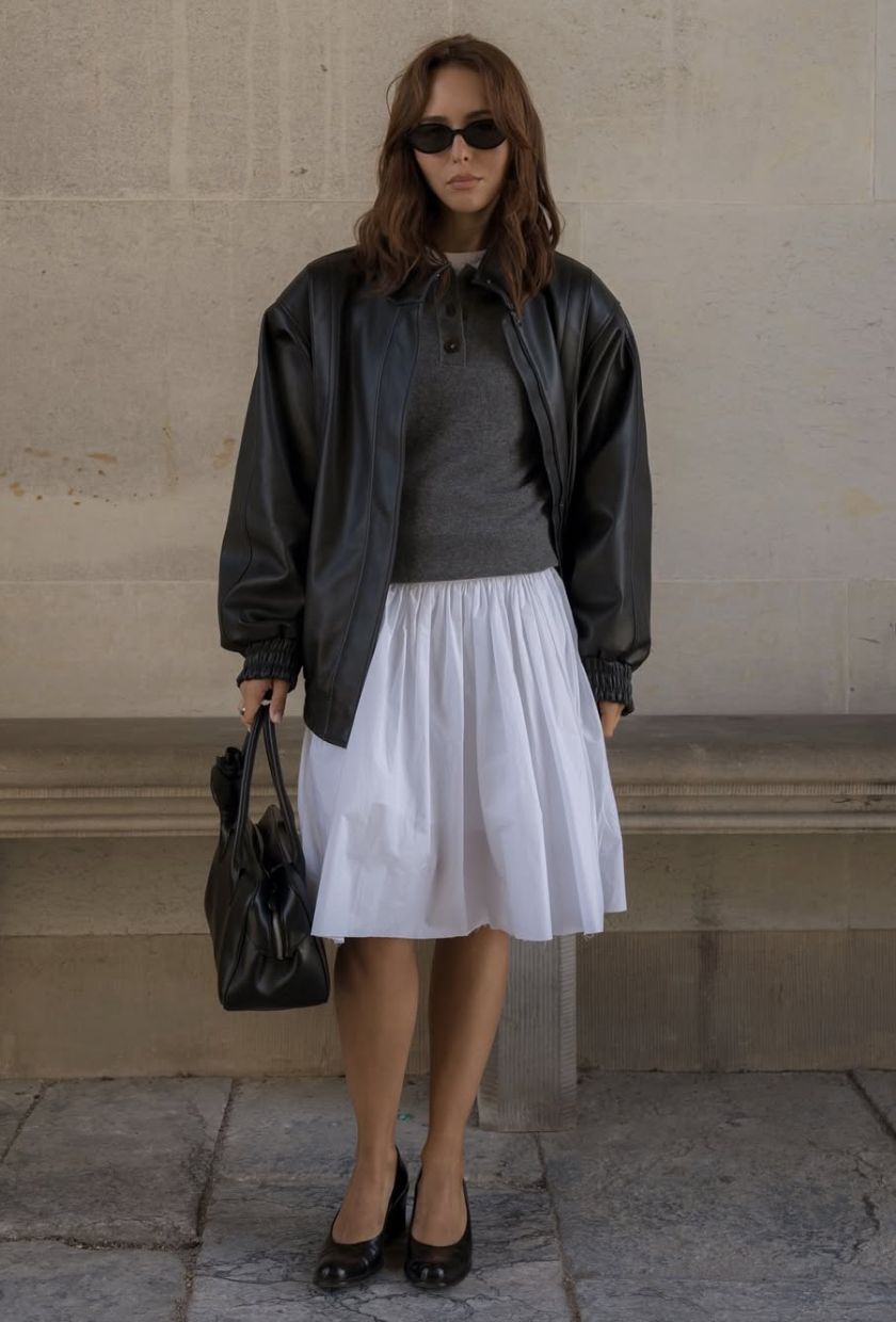 @deborabrosa wears a black leather bomber, grey jumper, white skirt, black ballet flats and bowling bag