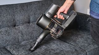 A black and gold Dreame R10 Pro cordless vacuum cleaner