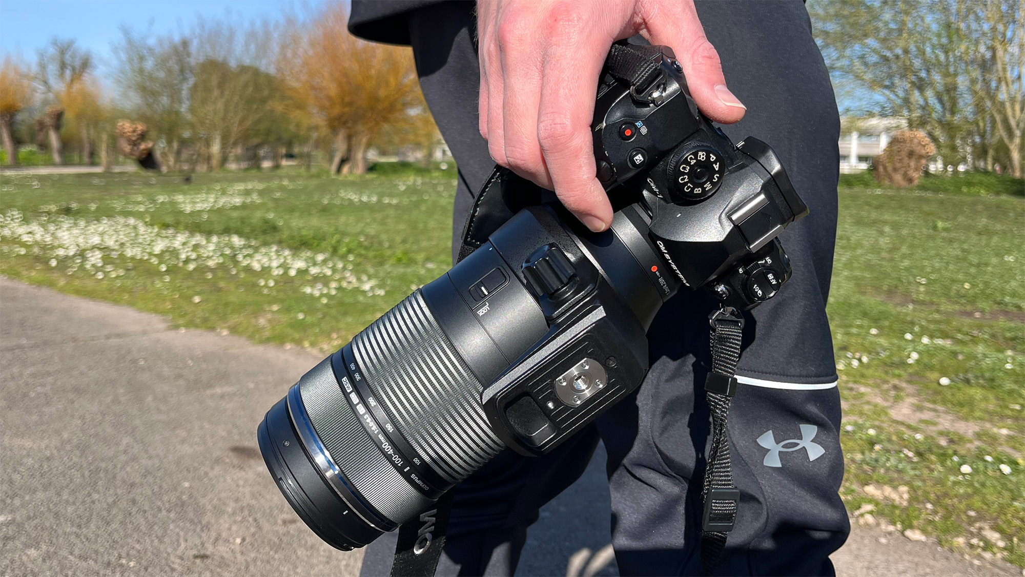 Mike Harris holding OM System OM-1 Mark II in green space