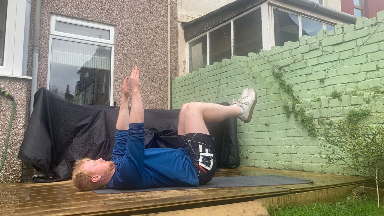 Fit&amp;Well fitness writer Harry Bullmore demonstrating a dead bug