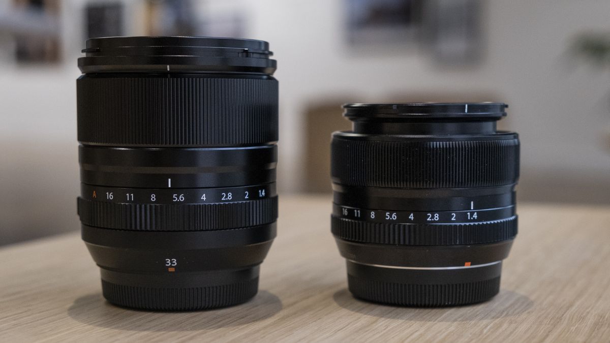 The Fujifilm XF33mm f/1.4 lens on a wooden table