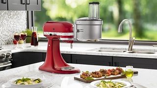 Red KitchenAid with food processor attachment sitting on a white worksurface