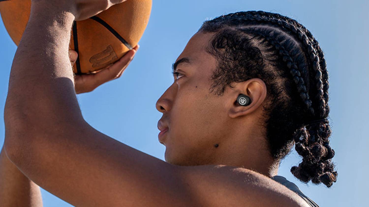 A basketball player with the JLab JBuds Mini ANC in their ear.